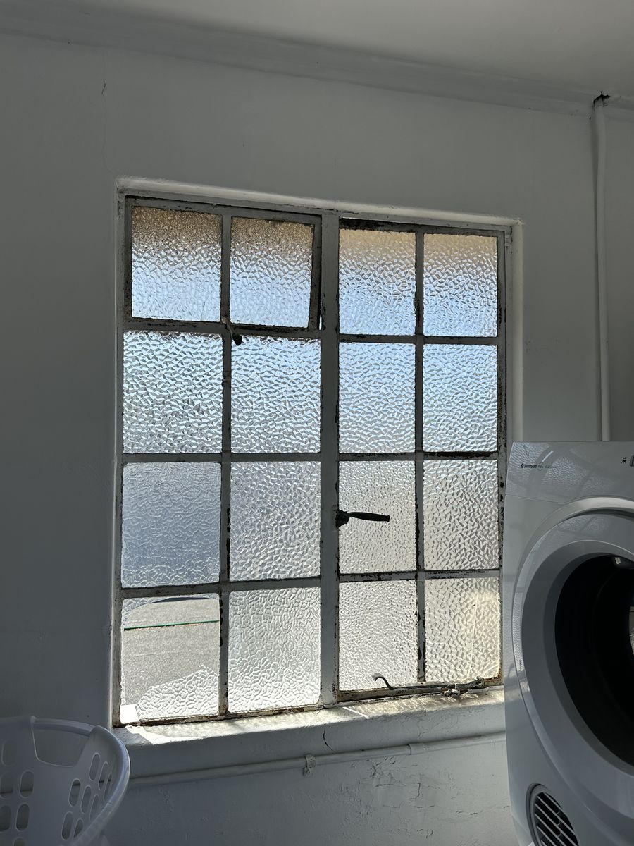 Original steel window with textured single glazing in a laundry